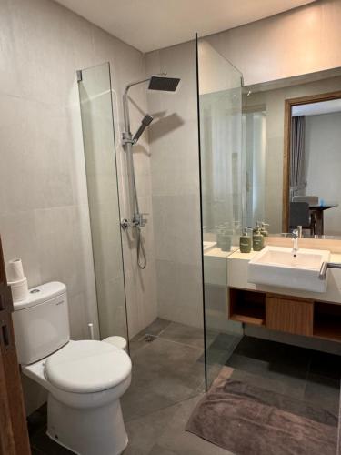 a bathroom with a toilet and a shower and a sink at Pejaten Park Residence in Jakarta