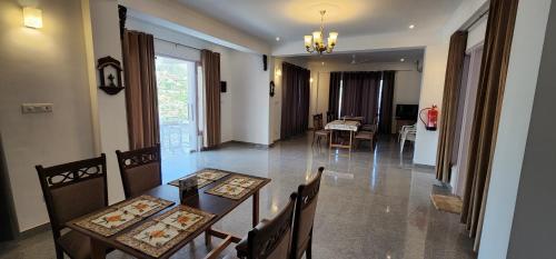 Un comedor con mesa y sillas y una sala de estar. en Hotel Dagshai Mist, en Dagshai