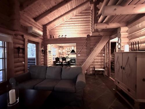 a living room with a couch in a log cabin at Villa Tsahkal Kilpisjärvi in Kilpisjärvi