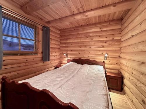 a bedroom with a bed in a wooden room at Villa Tsahkal Kilpisjärvi in Kilpisjärvi
