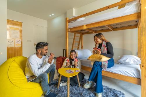 a group of people sitting in a room with bunk beds at ArtBuzz Dehradun in Dehradun