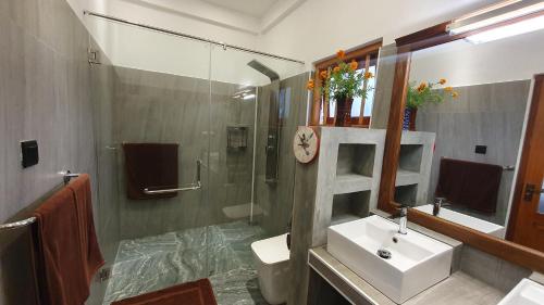 uma casa de banho com um lavatório, um WC e um chuveiro em Margaret House em Mirissa