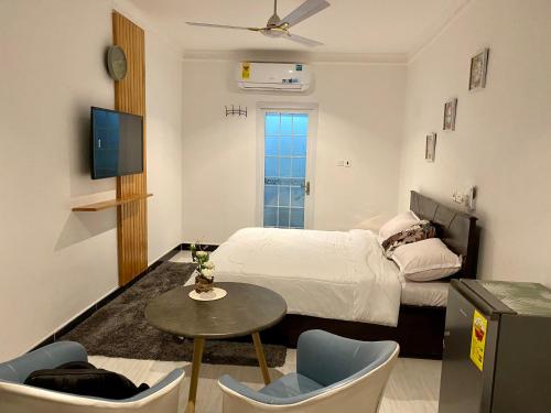 um quarto com uma cama, uma mesa e cadeiras em BryMac Hotel em Koforidua