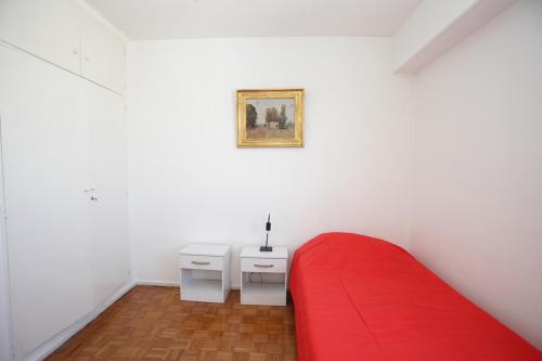 Un dormitorio con una cama roja y una pintura en la pared en Spacious 5BR Classic Apt in Palermo en Buenos Aires