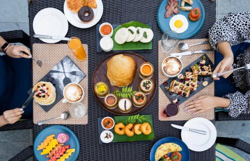 a group of people sitting around a table with breakfast foods at DoubleTree by Hilton Agra in Agra