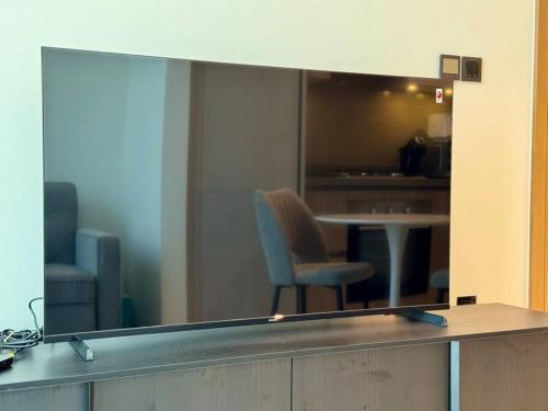 a reflection of a chair and a table in a window at Stylish brand new 1 bedroom in Dubai