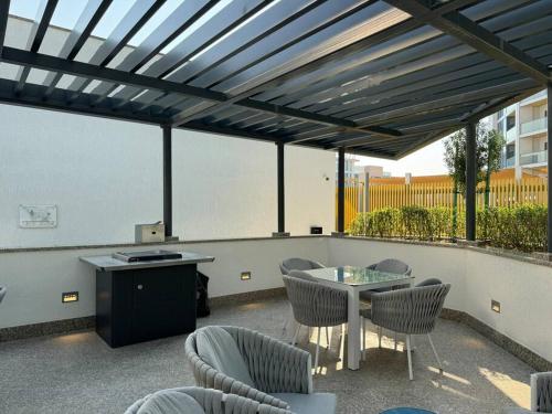 acovered patio with a table and chairs and a table and a tablektop at Stylish brand new 1 bedroom in Dubai