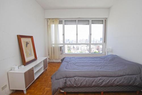 um quarto com uma cama e uma grande janela em Spacious 5BR Classic Apt in Palermo em Buenos Aires