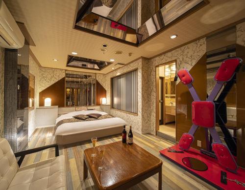 ein Schlafzimmer mit einem Bett, einem Sofa und einem Tisch in der Unterkunft Hotel Jardin de Fleurs (Adult Only) in Kyoto