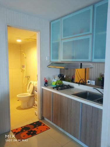 a kitchen with blue cabinets and a sink and a toilet at Apartement orchard Surabaya in Surabaya