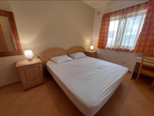 ビルキルカラにあるPrivate room in Shared apartment close to University of Malta & Mater Deiのベッドルーム1室(ベッド1台、ナイトスタンド2台、窓付)