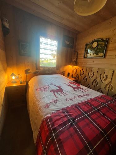 1 dormitorio con 1 cama en una habitación con ventana en l'écureuil, en Saint-Laurent-en-Grandvaux
