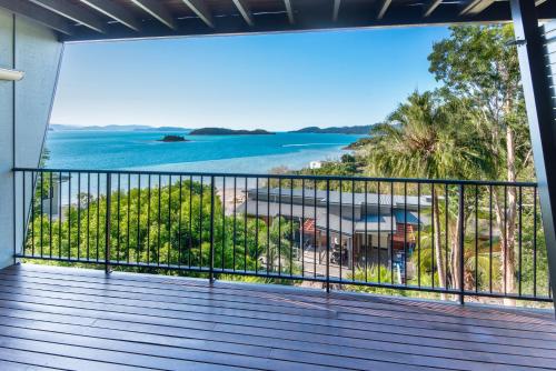 a balcony with a view of the ocean at Panorama 4 & Free Buggy - Hamilton Island in Hamilton Island