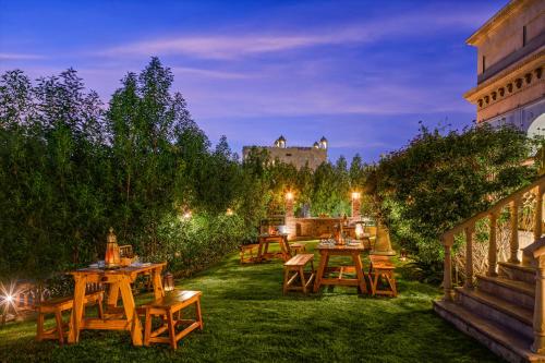 a group of tables in a garden at night at Fairmont Jaipur in Jaipur