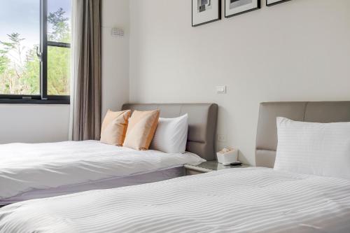 two beds sitting next to each other in a room at Dream Field in Luye