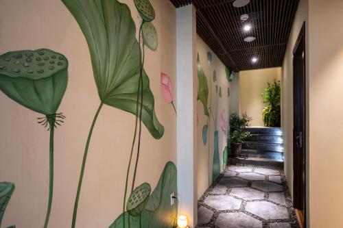 a hallway with a mural of a plant on the wall at Alagon Saigon Hotel & Spa in Ho Chi Minh City