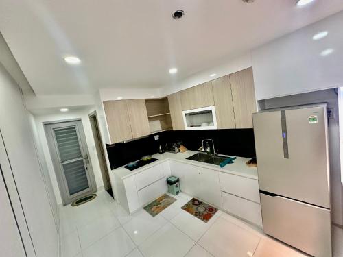 a kitchen with white cabinets and a stainless steel refrigerator at SCENIC VALLEY 1 in Ho Chi Minh City