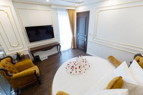 a living room with a white table and a television at Royal Dương Nội Hotel in Hanoi