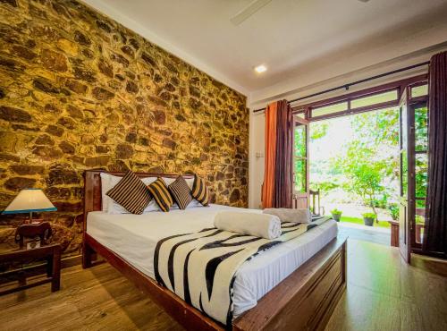 a bedroom with a bed with a stone wall at The Residence Ella in Ella