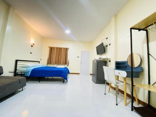 a hotel room with a blue bed and a desk at Panutsaya Homestay in Wang Nam Khieo