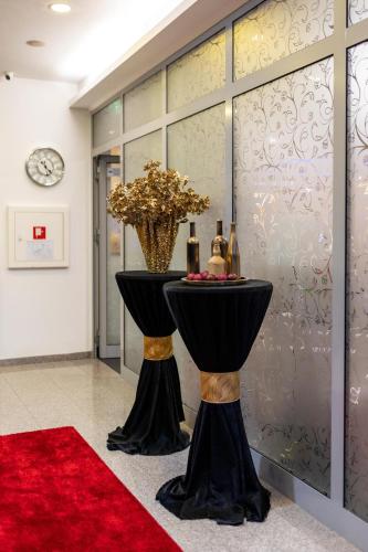a room with a table with bottles and a red carpet at Art Hotel in Slavonski Brod