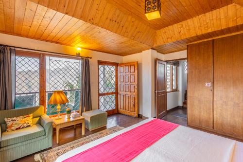 a bedroom with a bed and a couch and windows at Breezedale in Shimla