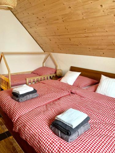 two beds in a room with red and white checked sheets at Chata pod horou in Stará Lesná