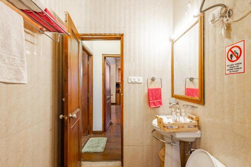 a bathroom with a sink and a toilet and a mirror at Breezedale in Shimla