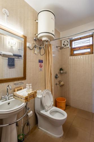 a bathroom with a white toilet and a sink at Breezedale in Shimla