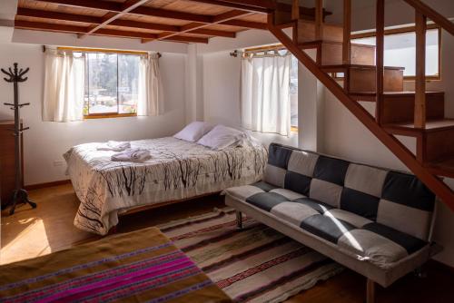 a bedroom with a bed and a couch in a room at Sumaq Wayra in Yanque