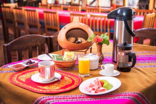 einen Tisch mit einem Frühstück mit Kaffee und Orangensaft in der Unterkunft Sumaq Wayra in Yanque