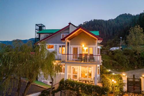 a house with a balcony on a hill at night at Breezedale in Shimla