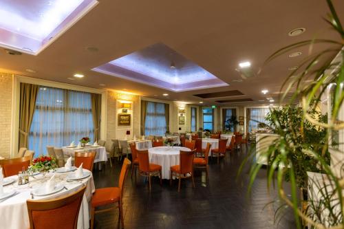 a dining room with white tables and chairs at Art Hotel in Slavonski Brod