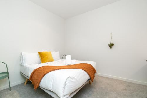 Dormitorio blanco con cama con almohadas amarillas en 2BR Penthouse with Breathtaking View! - Hosted by CanStay, en Canberra