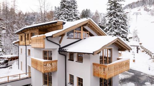 a house with snow on the roof at Chalet Marmotta CULM - Luxus Chalet Ski-In Ski-Out in Sankt Anton am Arlberg