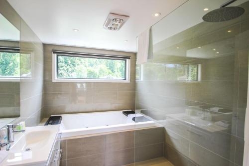 a bathroom with a tub and a sink and a window at The Base One in Harrietville