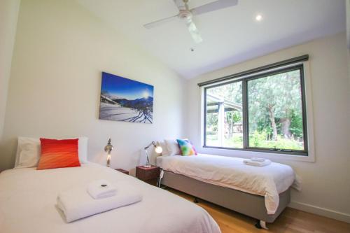 a bedroom with two beds and a window at The Base One in Harrietville