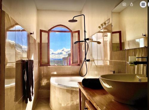 La salle de bains est pourvue d'une baignoire, d'un lavabo et d'une fenêtre. dans l'établissement Iarimbato Hotel, à Antananarivo