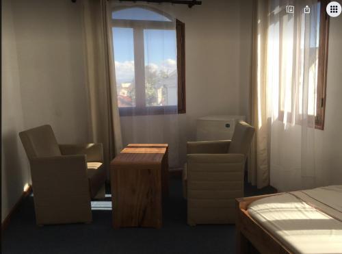 a room with chairs and a table and a window at Iarimbato Hotel in Antananarivo