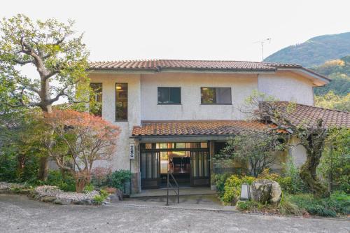 a house with a lot of trees in front of it at HOTEL LT Kitchen Yugawara in Yugawara