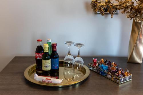 a tray with wine bottles and glasses on a table at Art Hotel in Slavonski Brod