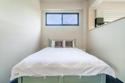 a small bedroom with a bed with a window at Dream Field in Luye