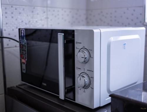 a microwave oven sitting on top of a counter at Tiny Haven executive one bedroom with Private Balcony in Nanyuki