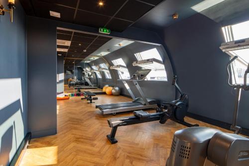 a gym with treadmills and ellipticals in a room at voco Paris - Porte de Clichy by IHG in Clichy