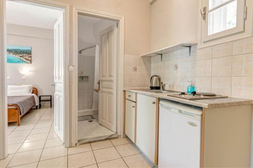 a kitchen with a sink and a bathroom with a bed at Alexandros Apartments in Ipsos