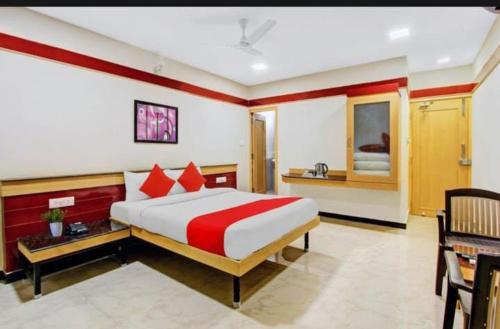 a bedroom with a large bed with red and white sheets at sri sai guru comfors in Bangalore