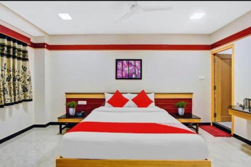 a bedroom with a large bed with red pillows at sri sai guru comfors in Bangalore