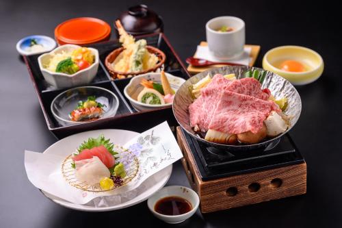 a table with plates of food and bowls of food at Hotel Green Park Suzuka in Suzuka