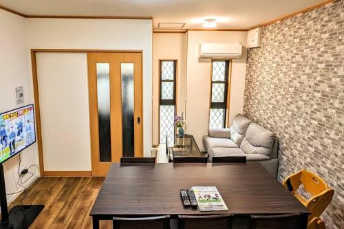 a living room with a table and a couch at ユニバーサルスタジオまで4駅20分海遊館近い 朝潮橋駅徒歩4分無料駐車場有り最大12名宿泊可能 Wifi ベビー用品充実 in Osaka