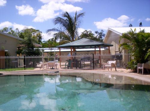 a swimming pool with a gazebo in a yard at The Park Motel in Charters Towers